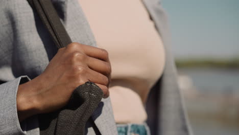 african-american woman with handbag walks along street