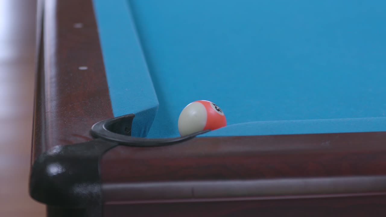 Man mist poolbal in hoekzak op blauwe biljarttafel