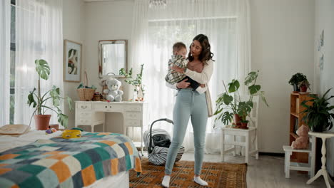 una madre feliz sosteniendo a su bebé en un dormitorio.