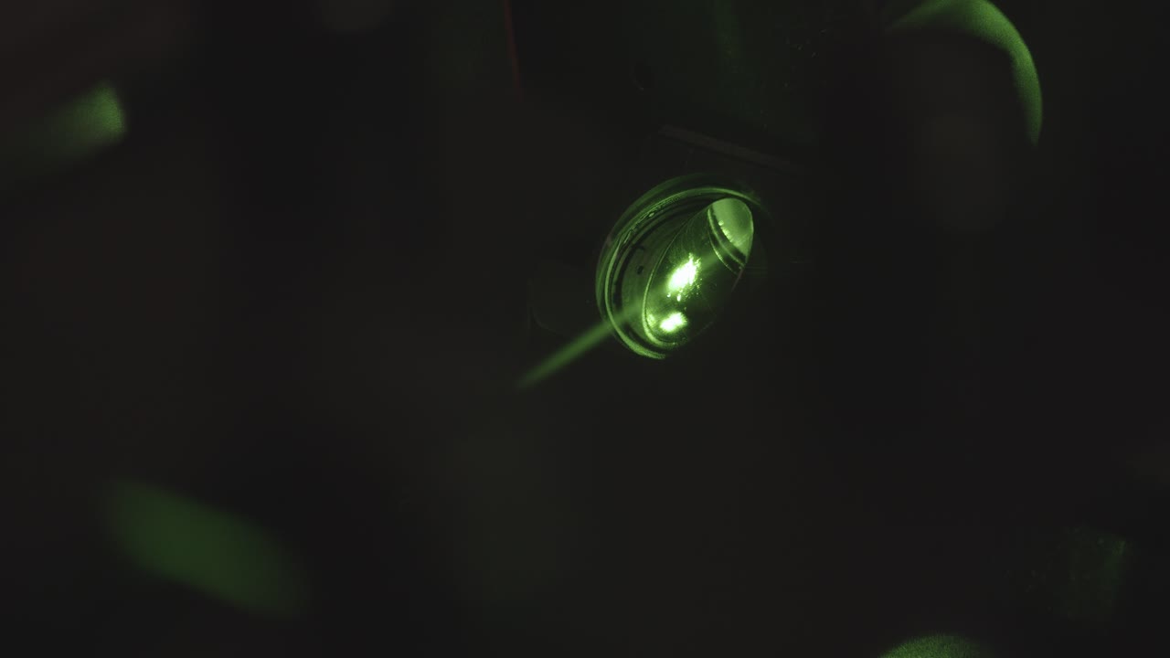 Green neon light projector with light flashing in dark room,close up shot. Party in night club.