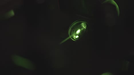 green neon light projector with light flashing in dark room,close up shot. party in night club.