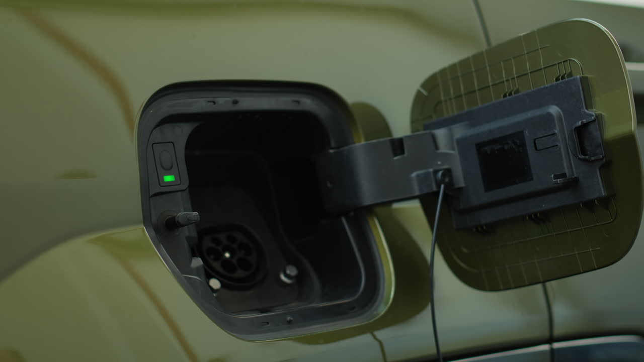 Close Up Of Eco Conscious Driver Opening Charging Port Flap Of Electric Car