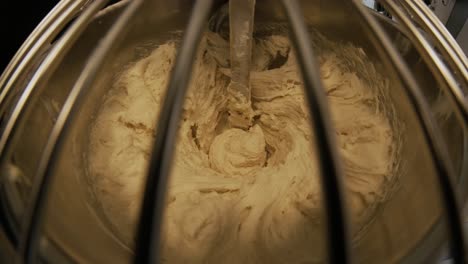 close-up of dough mixing in a professional kneader machine in kitchen of bakery or at the manufacturing. stock footage. dough making process