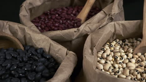 Narrow-focus-macro-closeup:-Nutritious-dry-beans-in-paper-bags-rotate