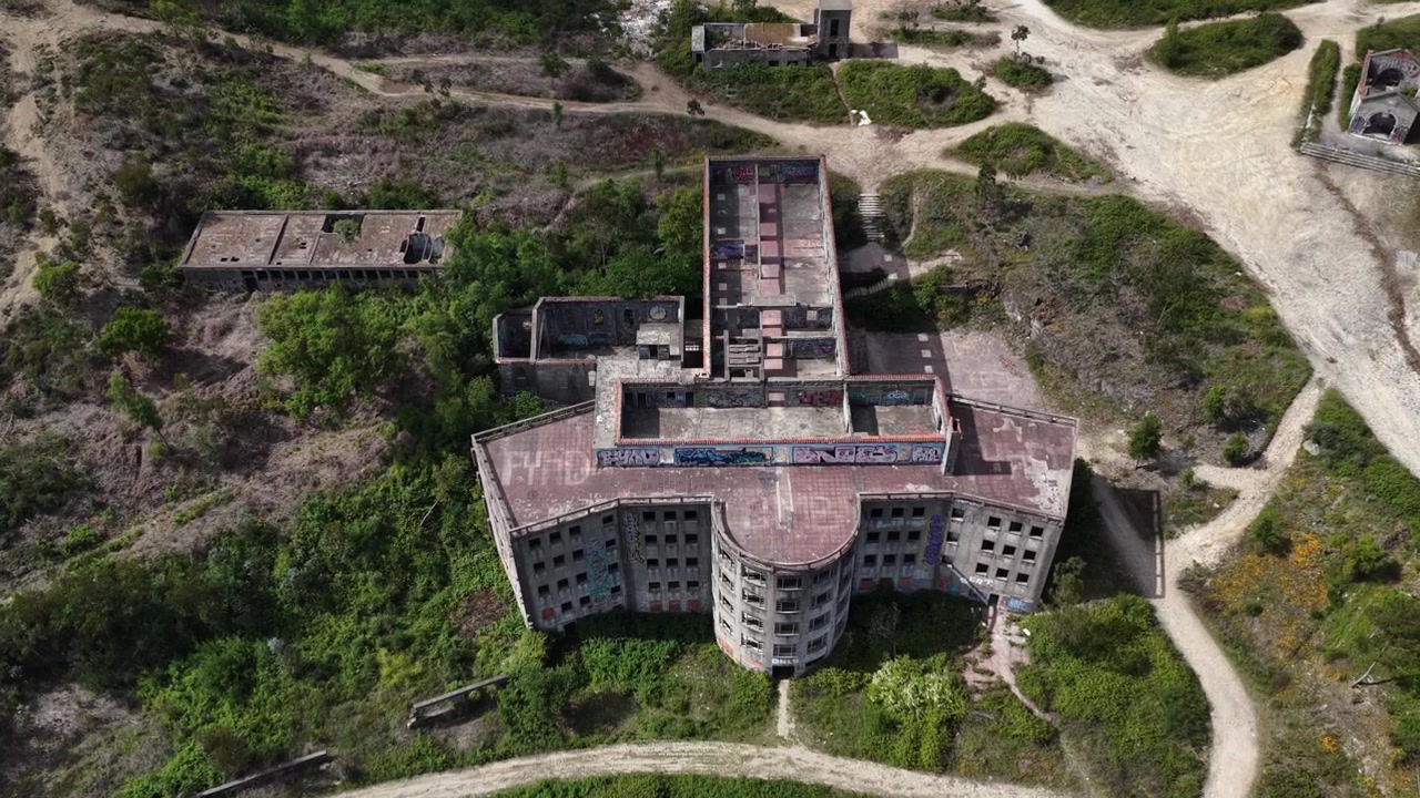 Ripresa con drone di un grande edificio abbandonato in montagna.