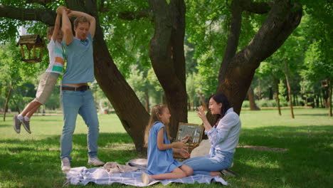 father hold on back little son on picnic. parents play with kids on summertime.