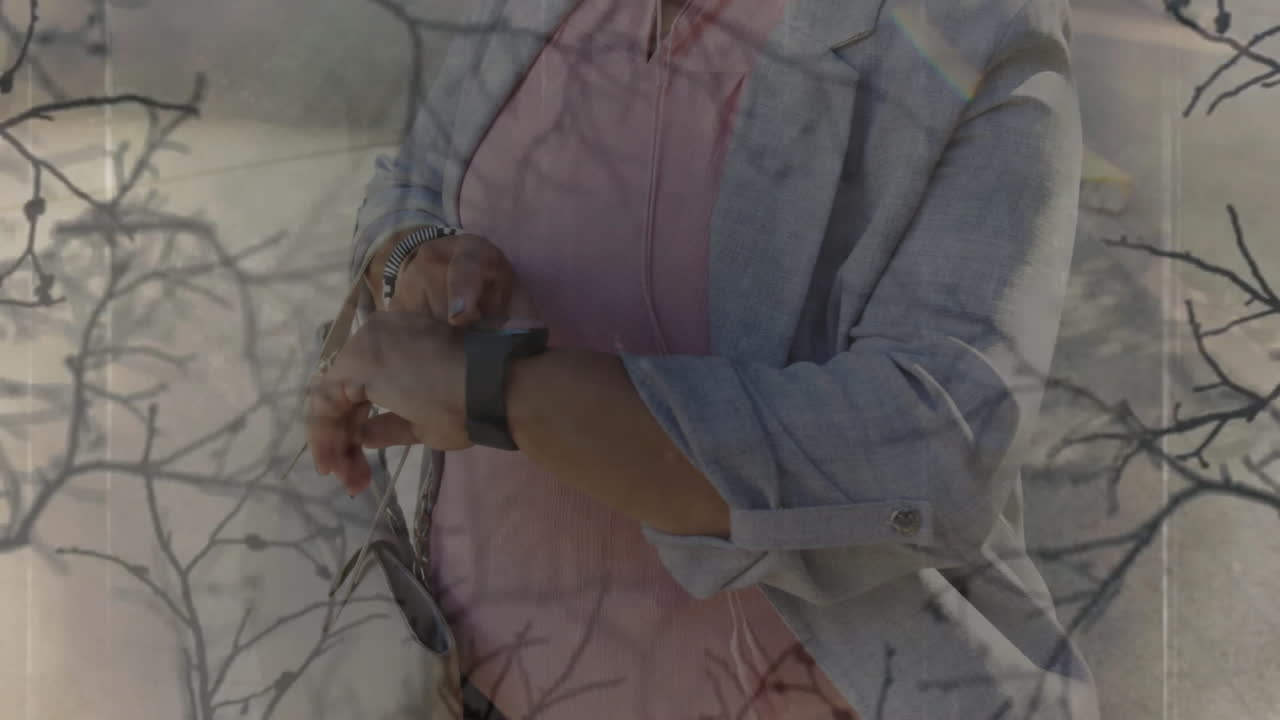 Professionista che tocca lo smartwatch all'aperto, mostrando grafici e dati tecnologici animati.