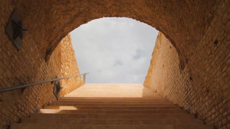 stone steps leading towards end of a tunnel inside of the roman circus in tarragona, spain - low angle