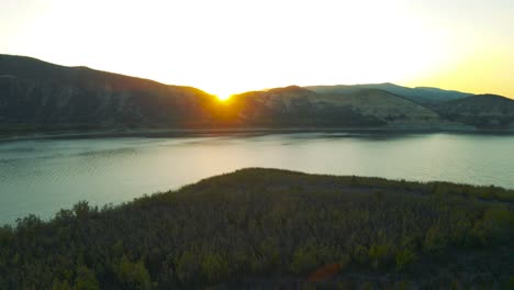 aerial view of the sun setting behind mountains at vail lake