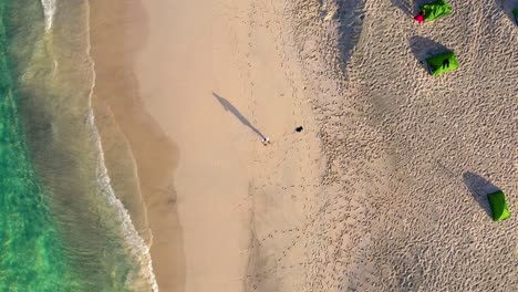 A-person-standing-alone-at-the-beach-near-a-camp-side,-Oman