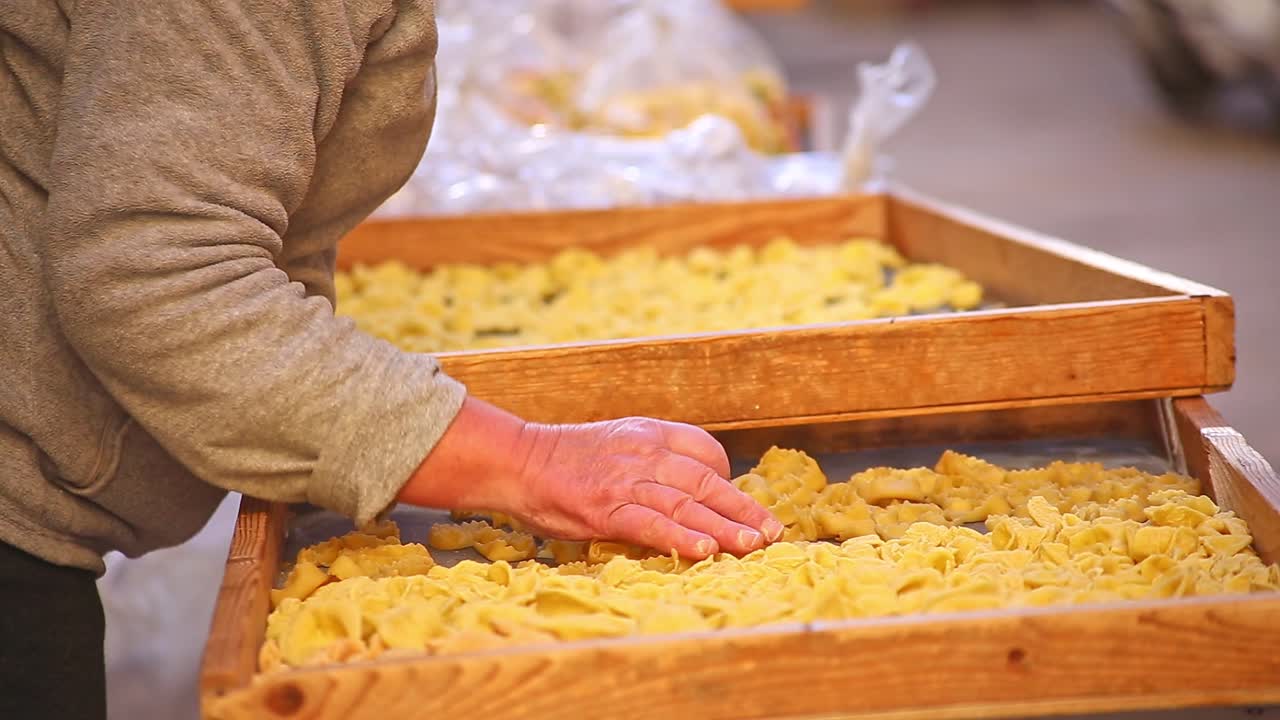 Close up of ladies hands touching and sorting pasta at market in Bari, Italy