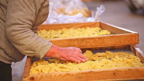 close up of ladies hands touching and sorting pasta at market in bari, italy