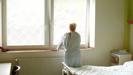 senior woman standing near window