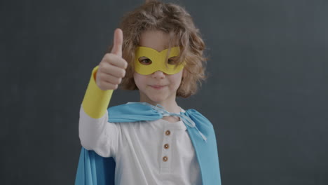 child dressed as superhero giving thumbs up