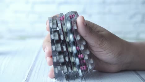 hand holding stack of pill packages