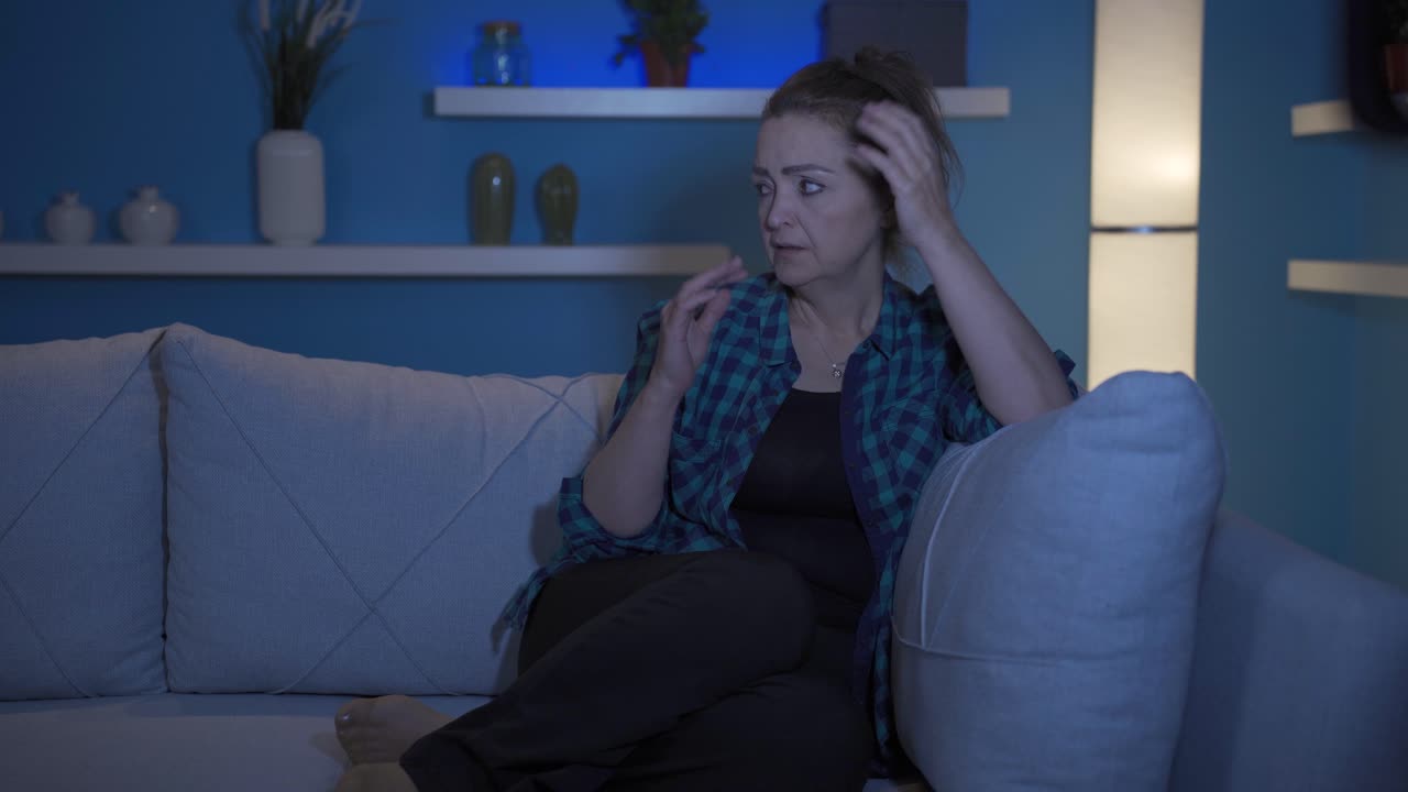Mulher sofrendo um colapso nervoso em casa à noite.