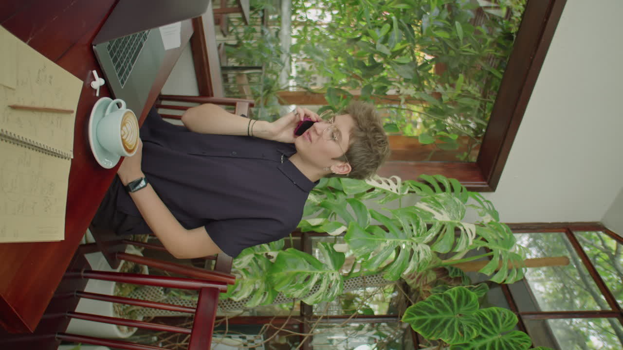 Businesswoman Having Phone Conversation in Outdoor Cafe