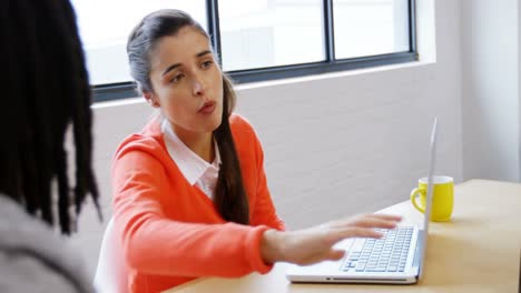 Male-and-female-business-executives-discussing-over-a-laptop