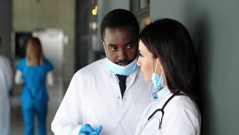 multi-ethnic male and female doctors standing in hospital, talking and consulting