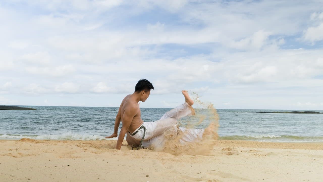 두 남자가 해변에서 카포에라를 춤추고 있다