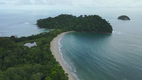 waves from the pacific ocean rooling at manuel antonio beach on a cloudy day