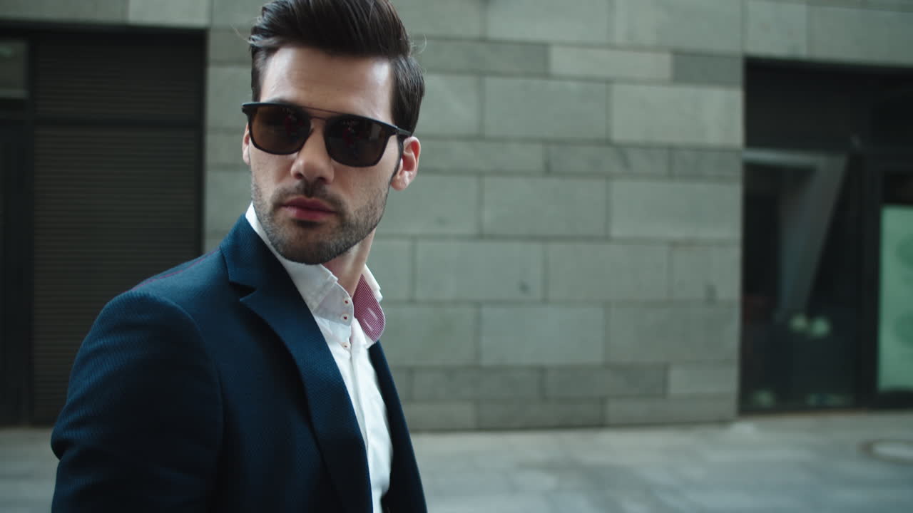 밖에서 선글라스를 착용 한 자신감 있는 사업가