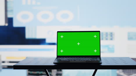 laptop with copy space display on empty desk next to infographics reports
