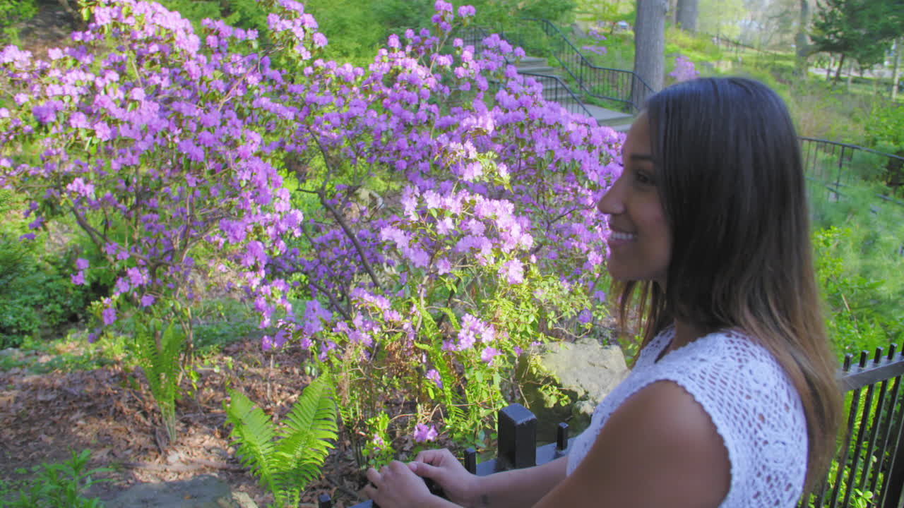 bonita, joven mujer sonriendo mientras mira las flores
