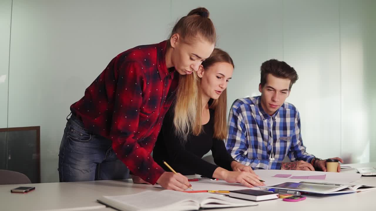 grupo de jóvenes diseñadores hipsters en ropa casual trabajando juntos en una sala de reuniones creando un proyecto juntos y compartiendo
