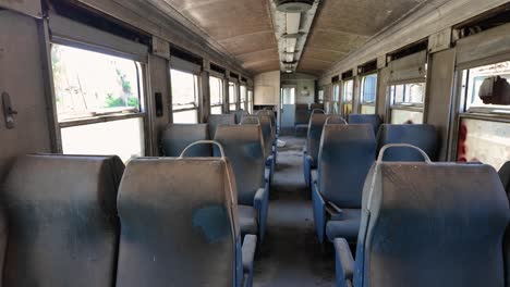 Old-Abandoned-Seats-In-An-Old-Train-In-Peloponnese,-Greece---Panning-Shot