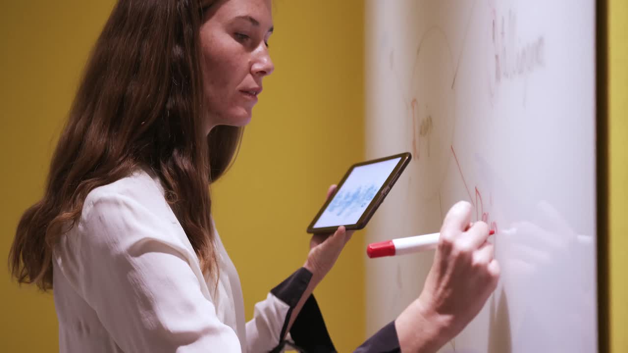 mujer de negocios creativa con escritura de mesa digital en pizarra en una oficina moderna