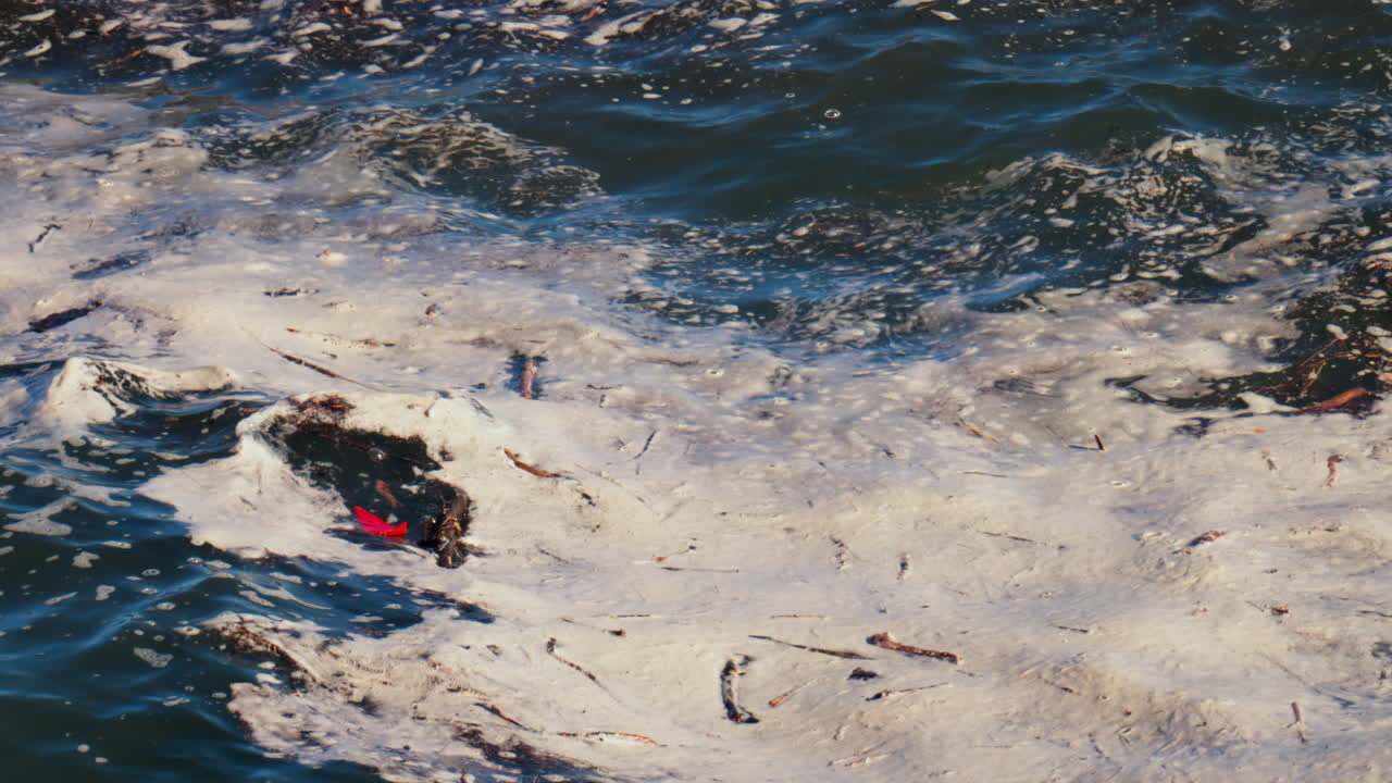 Close up of foam forming on the waves of the sea in daylight
