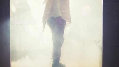 Cinematic-shot-of-an-LGBT-man-wearing-angel-wings-rising-and-turning-through-smoke