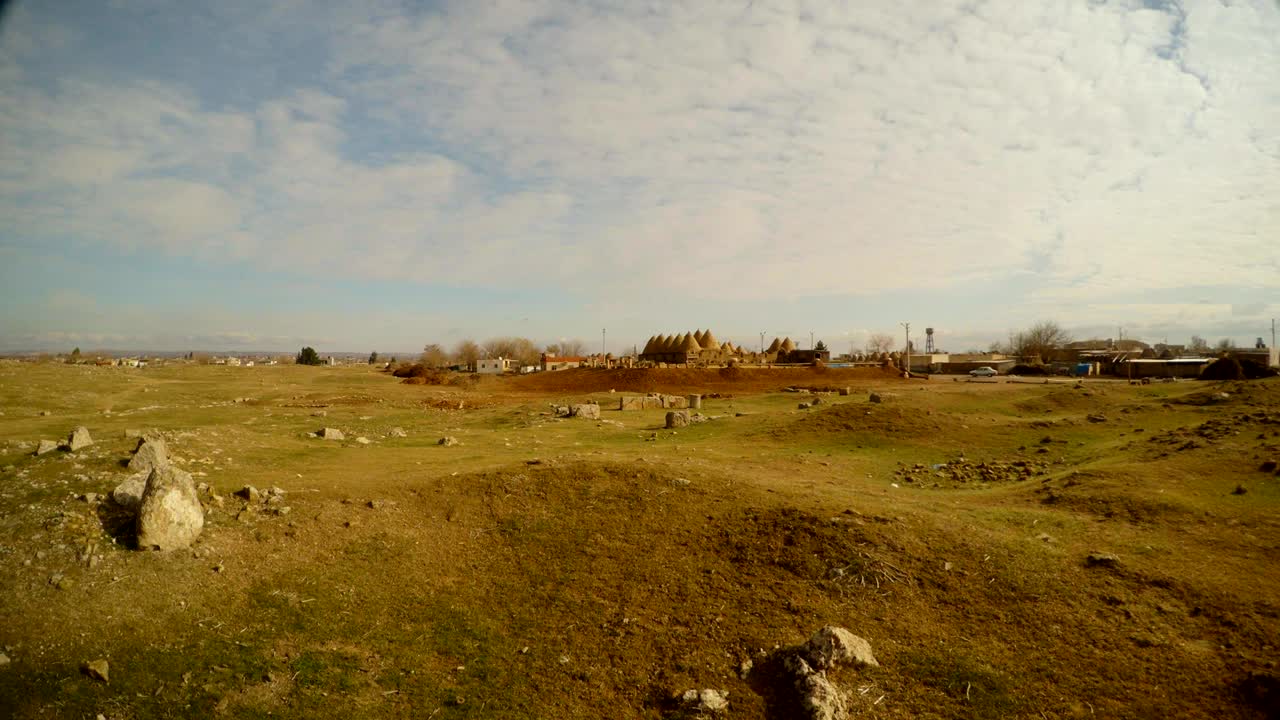 Villaggio di argilla mediorientale in lontananza, terra desolata al confine tra Siria e Turchia