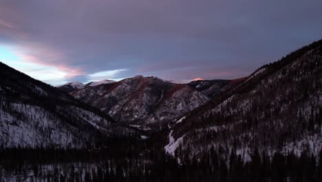 Sunset-drone-view-of-storm-clouds-over-a-mountain-peak-during-golden-hour