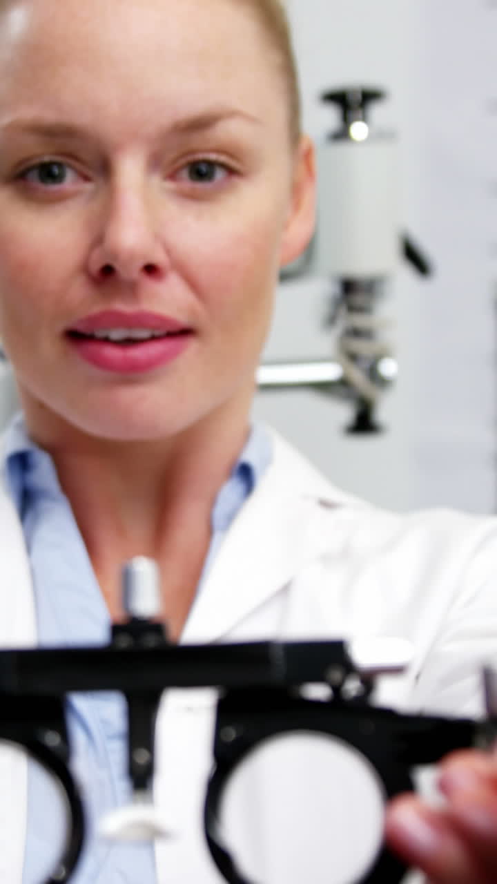 Smiling female optometrist holding messbrille