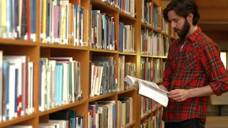 estudiante leyendo un libro de la biblioteca