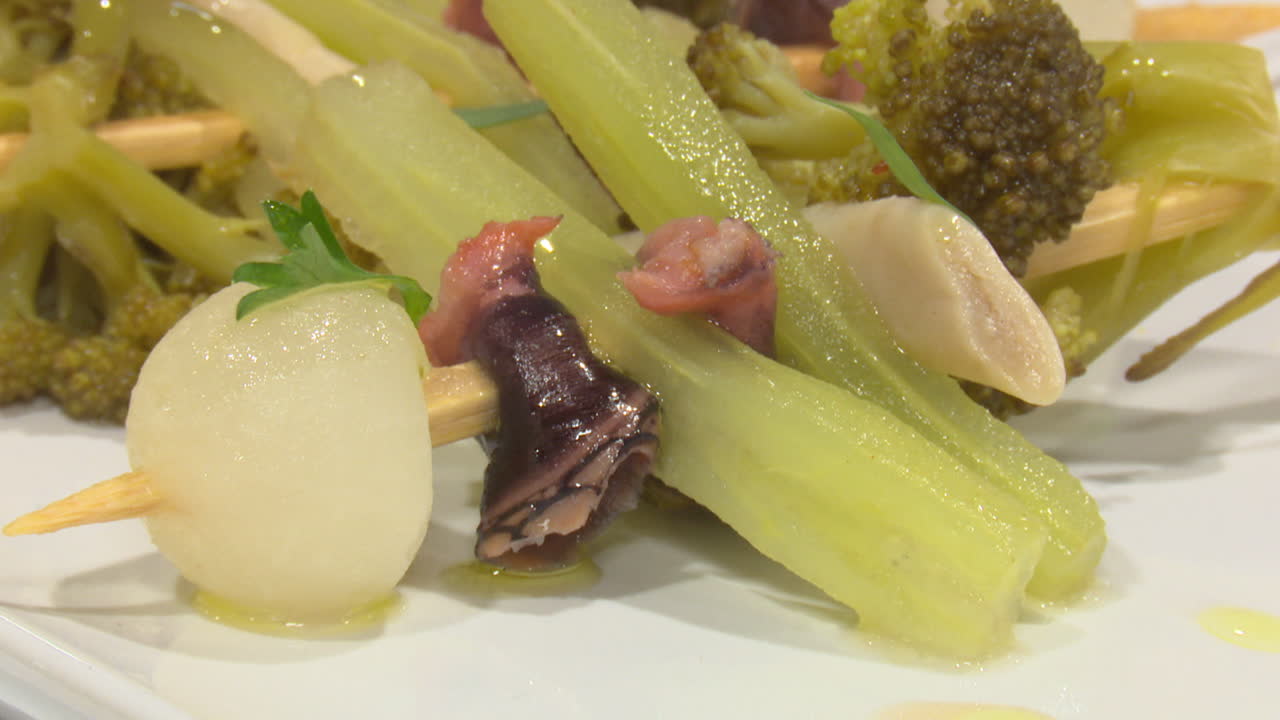 Close-up of a plate of fresh vegetables and seafood on wooden skewers