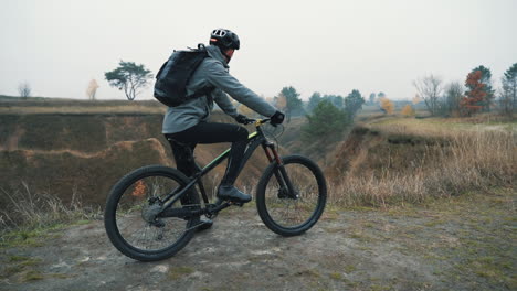 ciclista masculino listo para andar en bicicleta de montaña en la colina