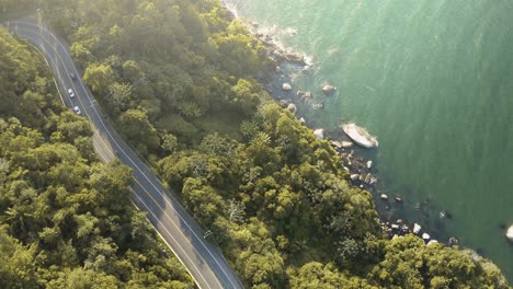 Aerial-view-from-above-showing-a-beautiful-scene-of-mountain-and-ocean-with-emerald-color-from-Interpraias-road-at-Balneario-Camboriu,-Santa-Catarina,-Brazil