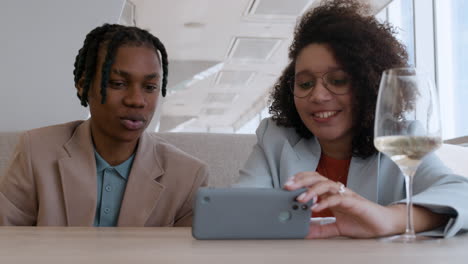 friends enjoying lunch and looking at a phone