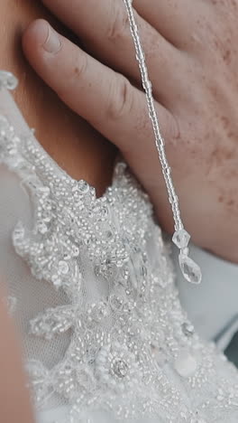 husband strokes elegant back of young wife in shiny white dress at wedding party closeup slow motion. happy couple on marriage day. love and tenderness