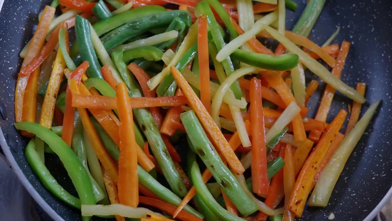 Verdure saltate in padella mescolate in una padella antiaderente, 4K.