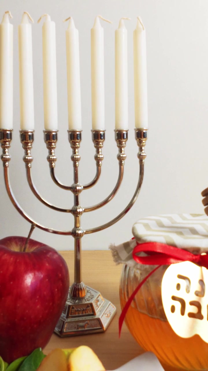 Rosh hashanah table setting with menorah, honey, and apple