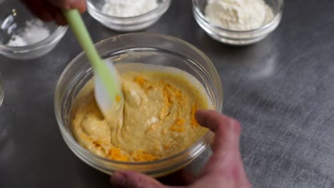 chef stirring pudding in a glass bowl