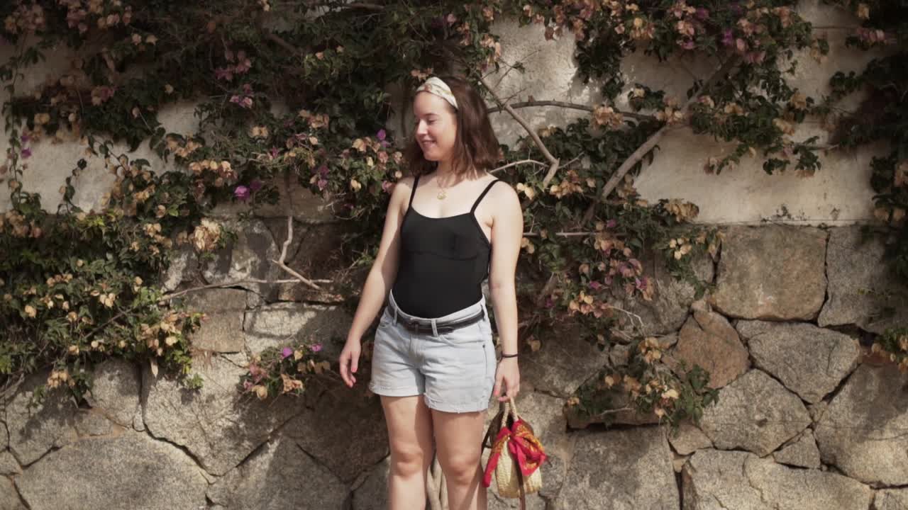 linda chica posa frente a una hermosa pared con hiedra en las bellezas de la costa brava