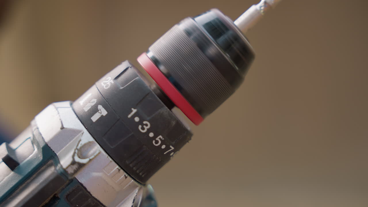 Closeup drill chuck with bit carpentry workshop showcasing precision woodworking, numbered torque ring, textured metal finish and subtle wear, warm studio lighting and shallow depth of field
