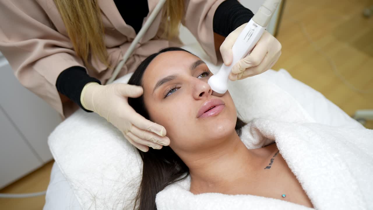 Mujer joven recibiendo tratamiento facial profesional en una clínica de belleza