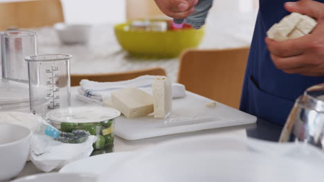 hombre cortando tofu en trozos para el plato en la clase de cocina de cocina