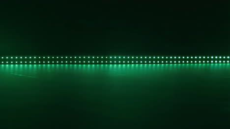 green led light strip with reflection on dark background